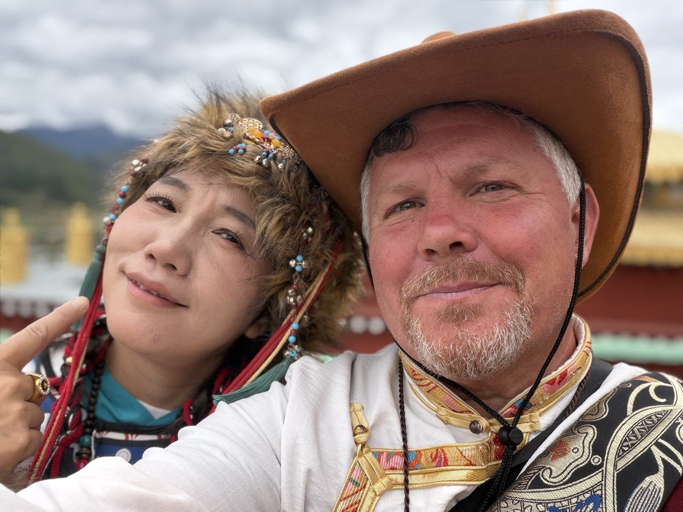 Joshua and Fengyi smiling in traditional dress during their travels